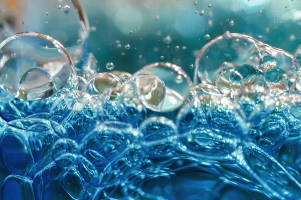 Blauwe bubbels in helder water tegen Wit — Stockfoto