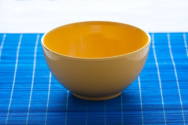 Yellow bowl on the blue pad - stock photo — Stock Photo, Image