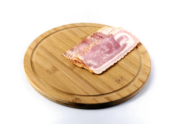 Bacon em um rolo de pão branco macio na placa branca — Fotografia de Stock