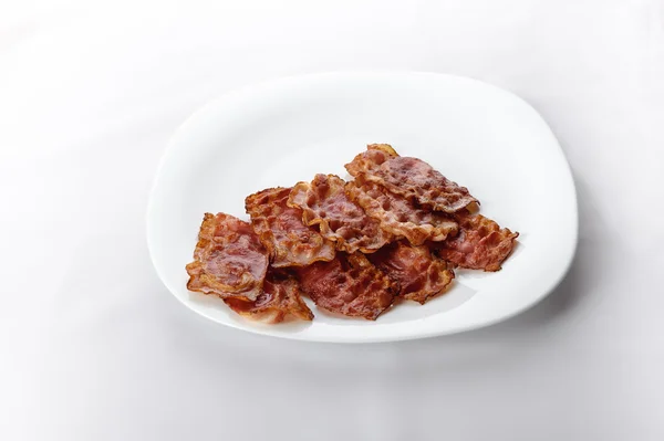 Bacon dans un rouleau de pain blanc doux sur plaque blanche — Photo