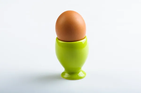 Copo de ovo verde no fundo azul — Fotografia de Stock
