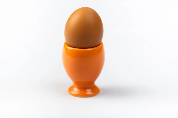 Copo de ovo laranja no fundo azul — Fotografia de Stock