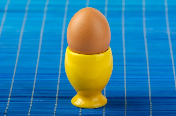Copo de ovo amarelo no fundo azul — Fotografia de Stock