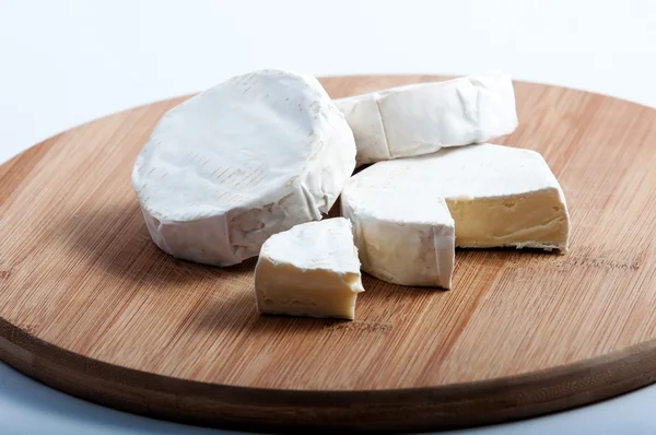 Unos trozos de queso en una tabla de madera — Foto de Stock