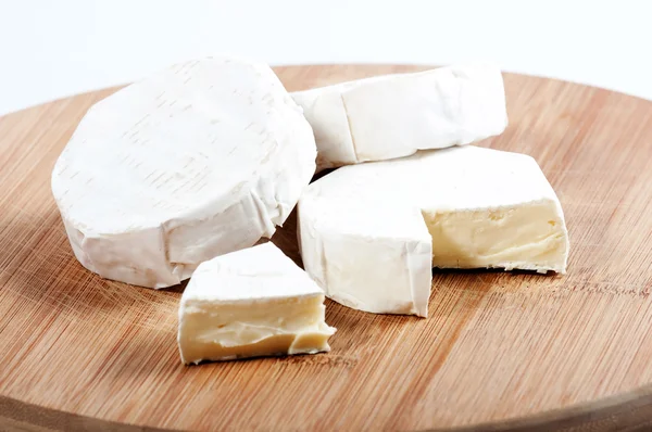 Alcuni pezzi di formaggio su una tavola di legno — Foto Stock