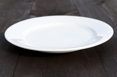 ahşap masa üzerinde beyaz tabak