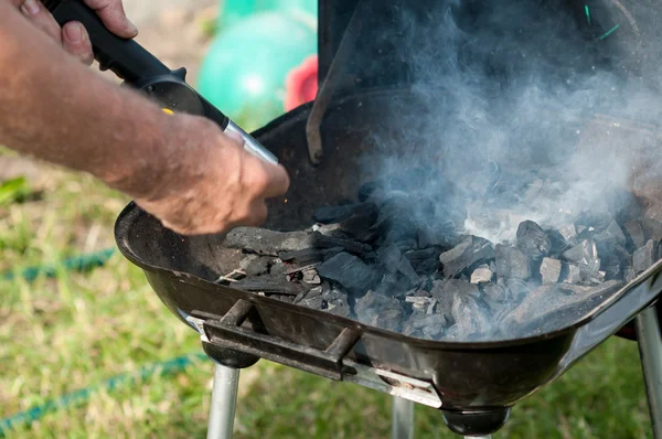 Firing up the grill, kindling fire — Stock Photo, Image