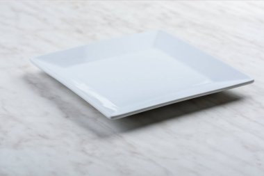 Çeşitli malzemelerden yapılmış doğal tabloların üzerinde beyaz kare plaka