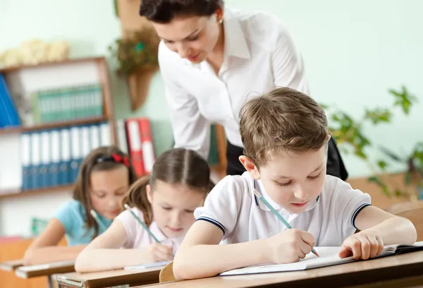 Profesor lleva a cabo la tarea realizando — Foto de Stock