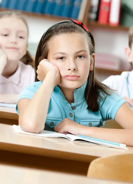 Triest mooie schoolmeisje op school — Stockfoto