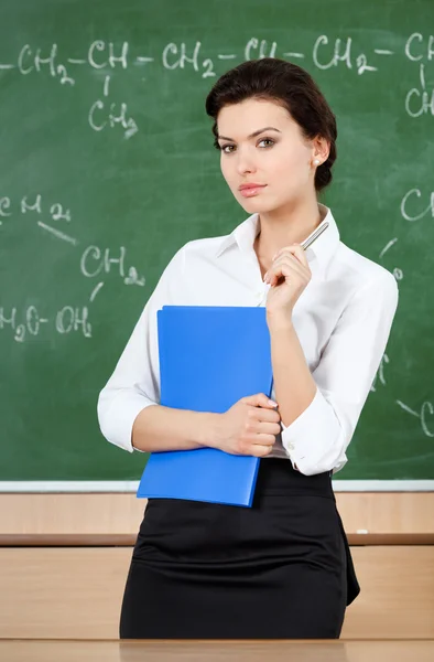 Serious teacher is at the blackboard — Stock Photo, Image