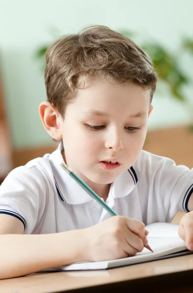 Schoolboy does some notes on the sheet of paper, close up Stock Picture