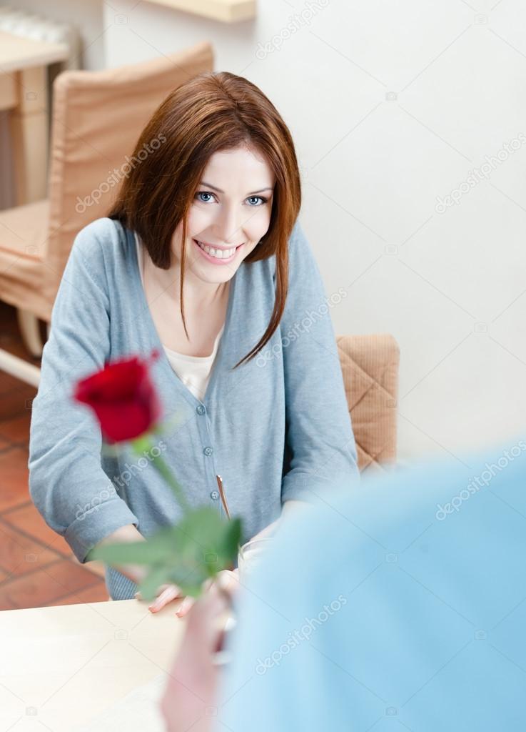 Attractive man presents a scarlet rose to his girlfriend