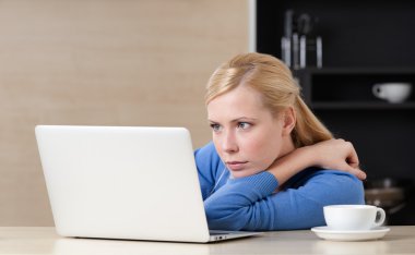 kadın bir fincan çay ile internette sörf yapar.