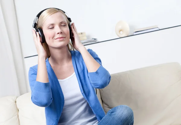 Mulher bonita em fones de ouvido ouve música — Fotografia de Stock