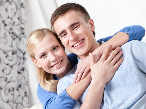 Happy couple sits on the couch — Stock Photo, Image