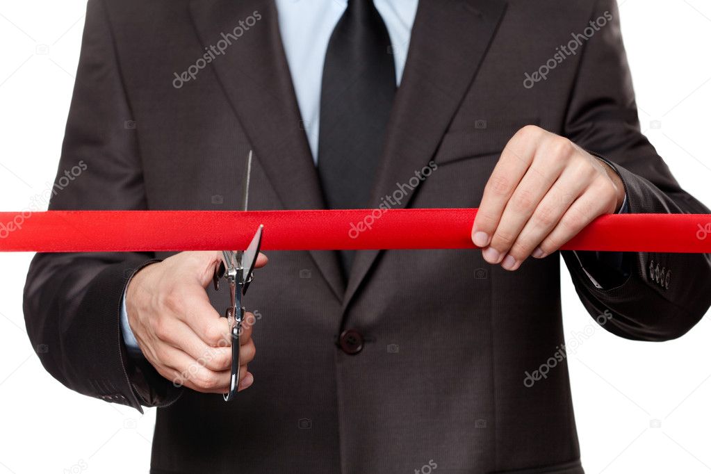 A businessman cutting a satin ribbon