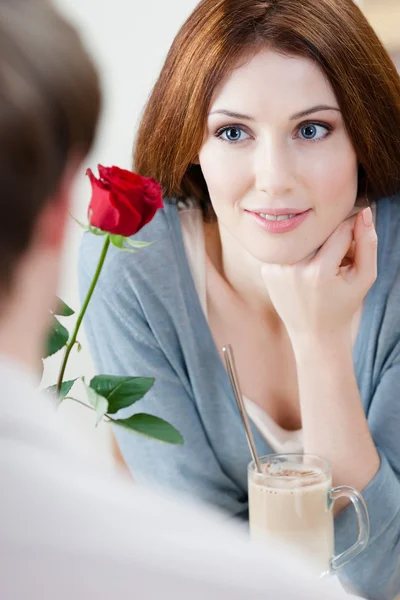 Vrouw in het café met rode roos — Stockfoto