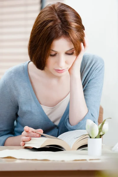 Woman reads the book at the shop — Stock Photo, Image