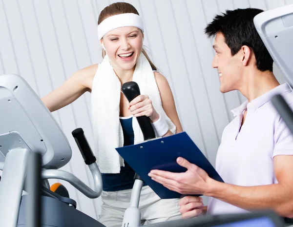 Athletic woman training on gym training in gym with coach — Stock Photo, Image