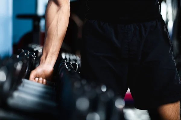 Hand selecting a dumbbell — Stock Photo, Image