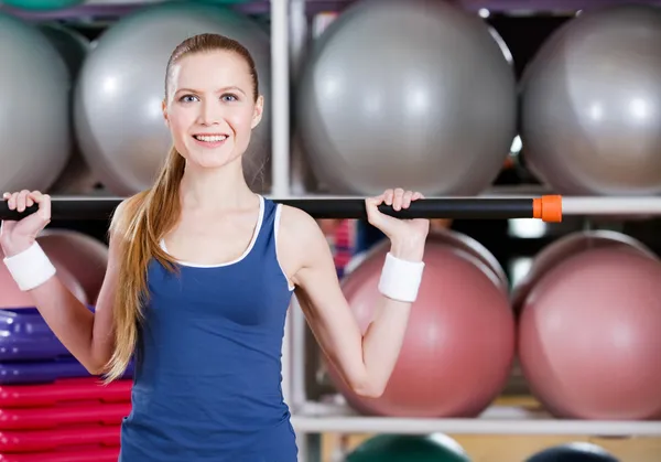 Athletic woman works out with gymnastic stick — Stock Photo, Image