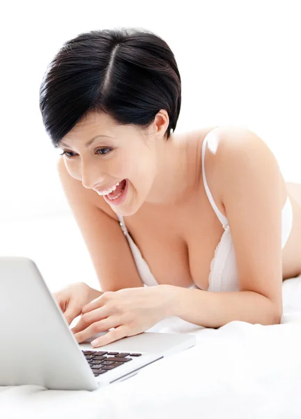 Woman in underwear is working on the silver laptop — Stock Photo, Image