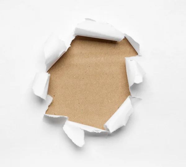 Дыра разорвана в белой бумаге — стоковое фото