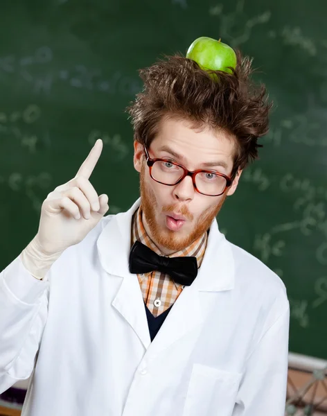 Mad professor met een appel op zijn hoofd toont wijsvinger — Stockfoto