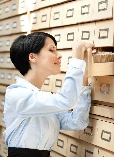 Bella dama busca algo en el catálogo de tarjetas — Foto de Stock