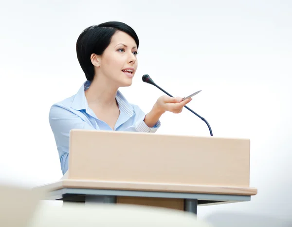 Pretty woman speaker at the podium — Stock Photo, Image