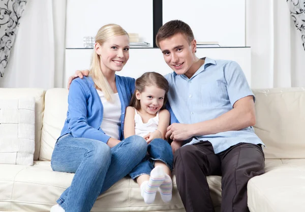Happy family hug each other on the sofa — Stock Photo, Image