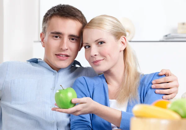 Mooie vrouw biedt een appel aan haar echtgenoot — Stockfoto