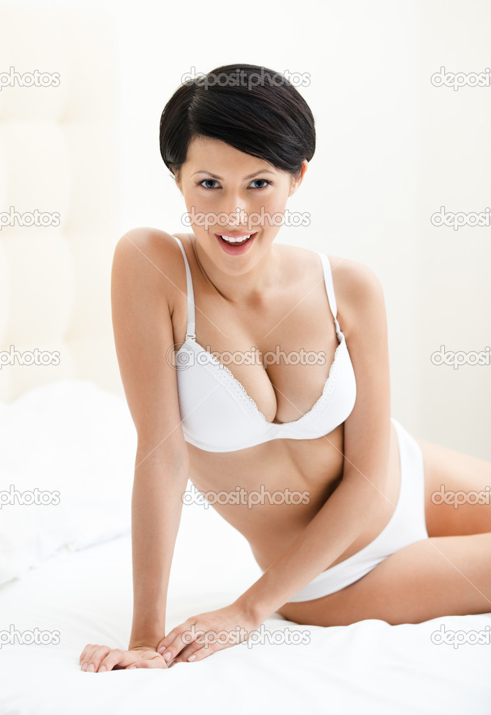 Halfnaked woman sits on the soft bed