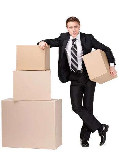 Manager stands near pile of cardboard boxes — Stock Photo, Image