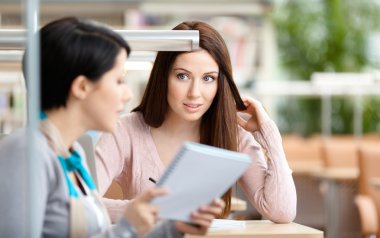 iki kadın masada oturan iletişim kurmak.