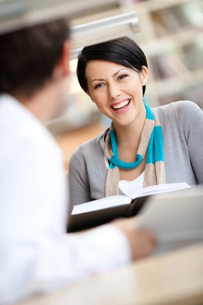 Girl communicates with handsome man at the library — Stock fotografie