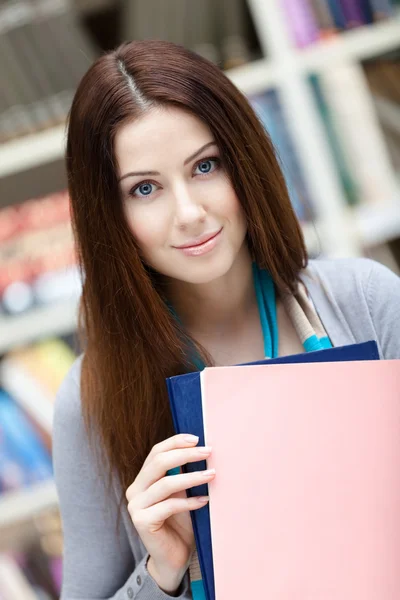 Female student with books at the library — Stock Photo, Image