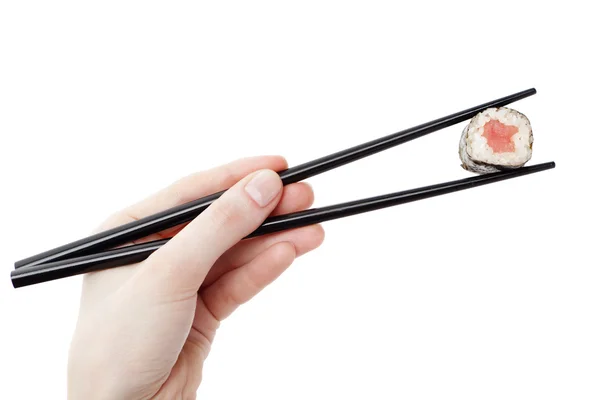 Hand holding sushi roll with chopsticks — Stock Photo, Image