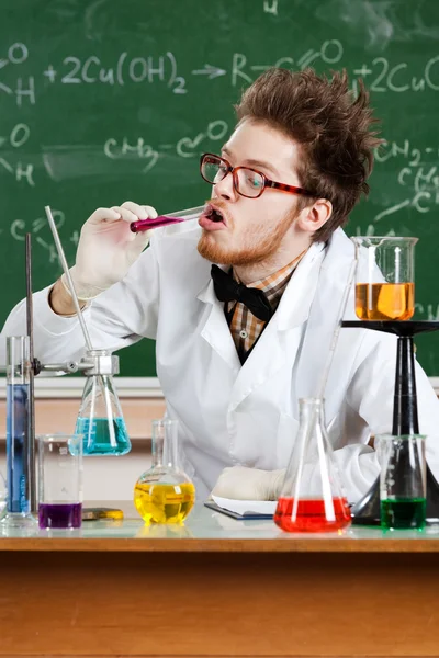 Mad professor smakar vätskan i ampullen — Stockfoto