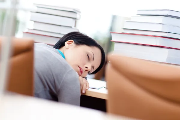 Tired female student sleeps at the desk — Stock Photo, Image