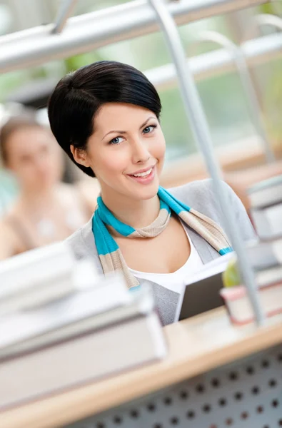 Pretty girl reads at the library — Stock Photo, Image