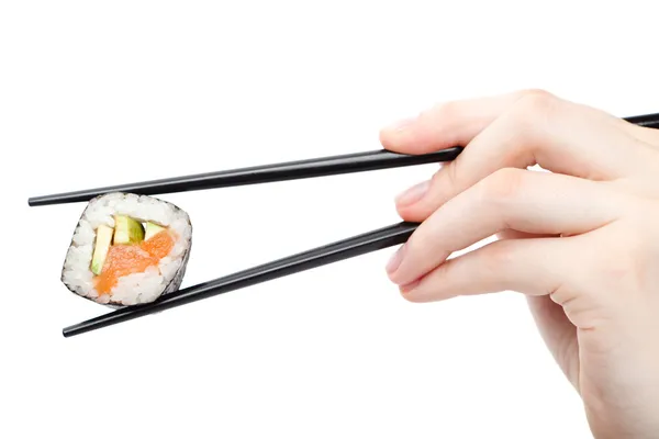 Hand holding sushi roll with black chopsticks — Stock Photo, Image