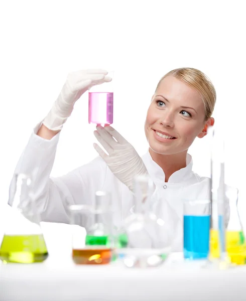 Young lady scientist looks at the beaker — Stock Photo, Image