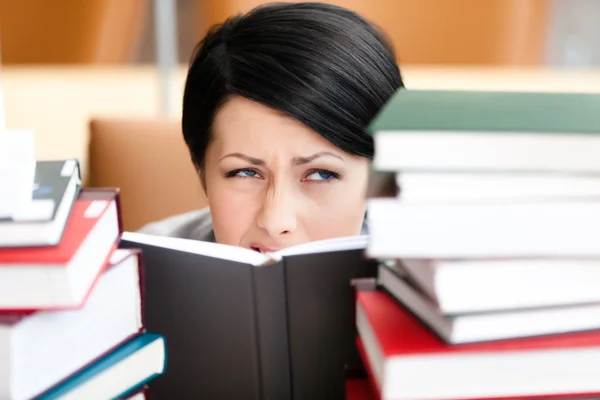 Pretty female student looks out over the book — Stock Photo, Image