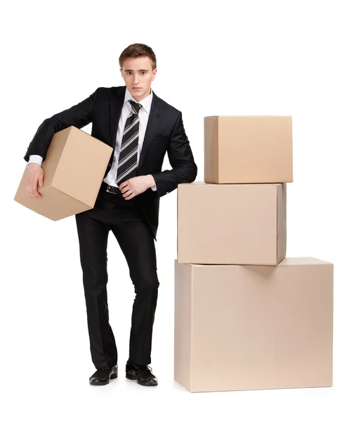 Manager stands near pile of boxes — Stock Photo, Image