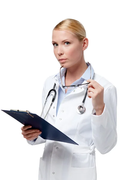 Женщина-врач пишет в блокноте: Лицензионные Стоковые Изображения