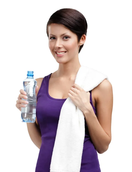 Athletic woman with bottle of water and towel — Stock Photo, Image
