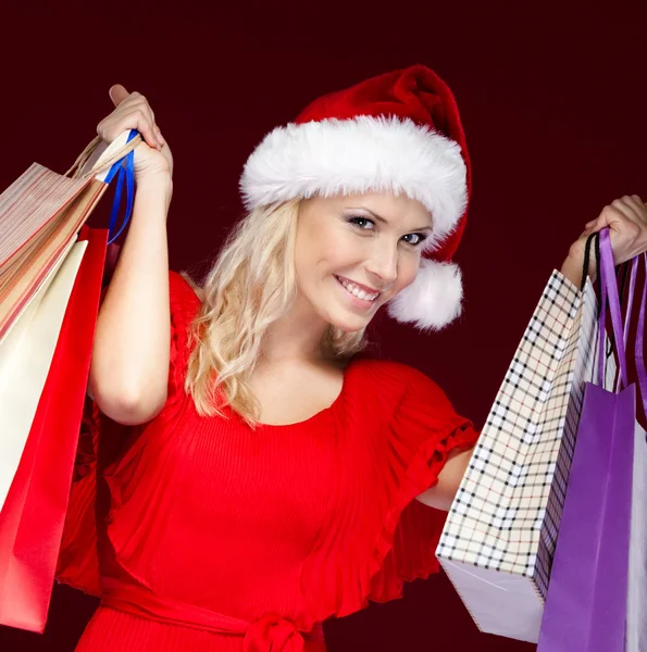 Young woman in Christmas cap hands paper packets — Stock Photo, Image