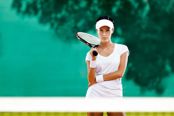 Unga idrottskvinna med racket på tennisbanan — Stockfoto
